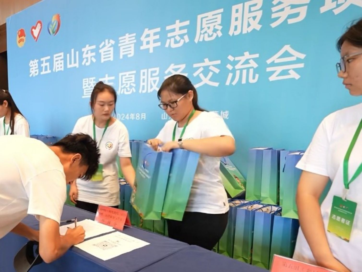 圖為“新奇”實踐團(tuán)成員給參賽者分發(fā)會務(wù)包
